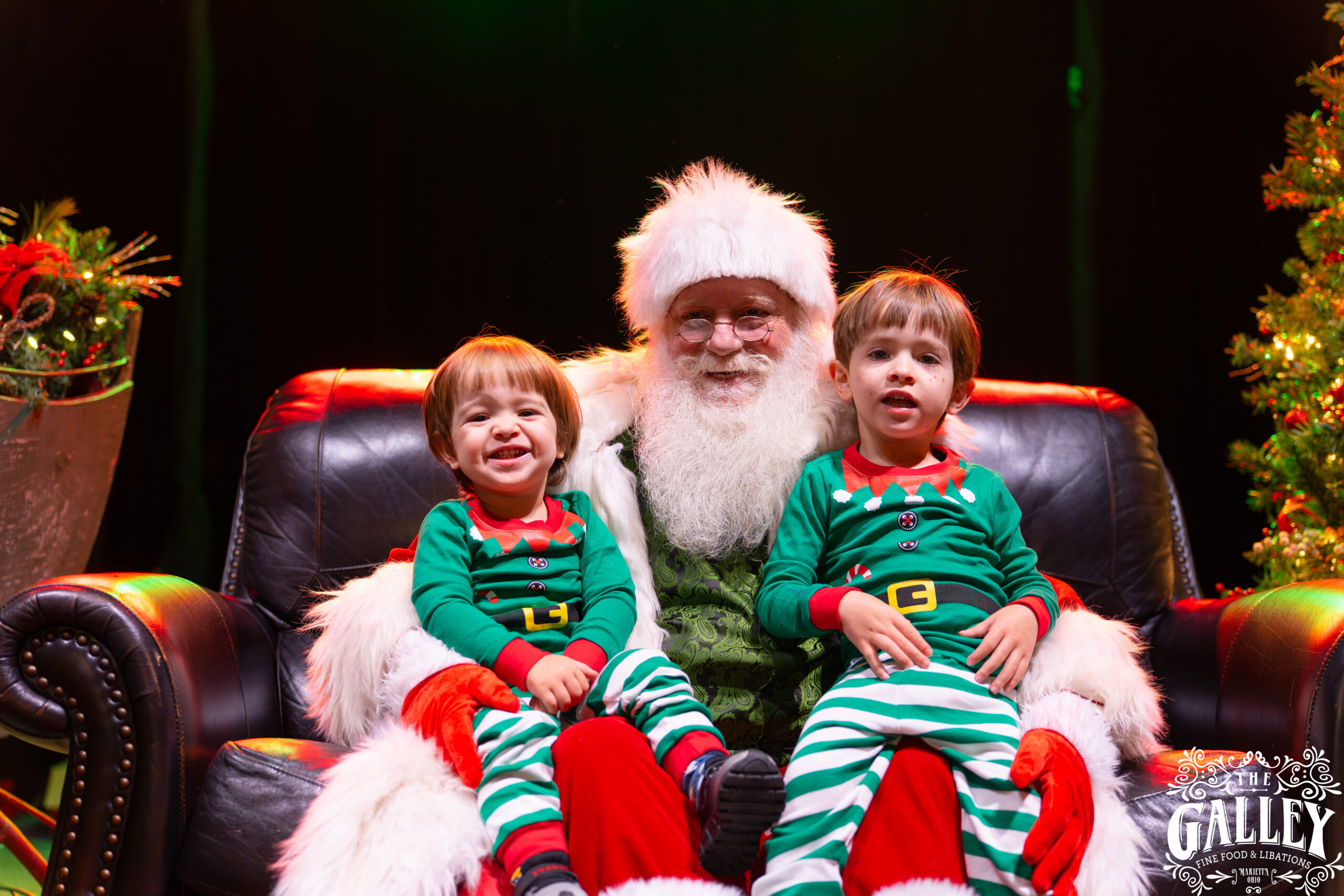Santa sitting with two children in matching green holiday pajamas at The Galley